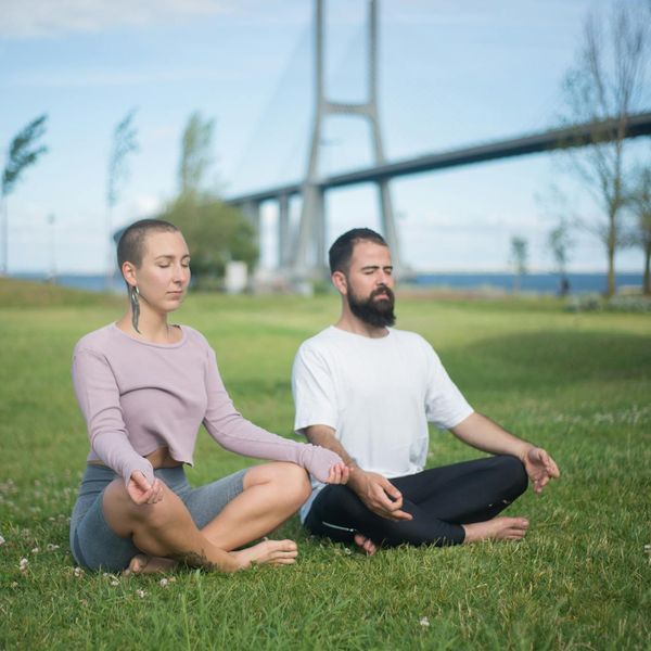 Person meditating peacefully in a natural outdoor setting.